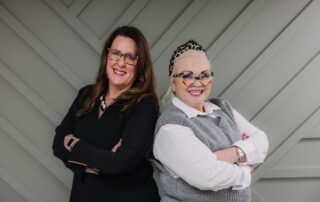 Coach Jennifer Pearce and Dr. Heather Larrimore standing back-to-back smiling