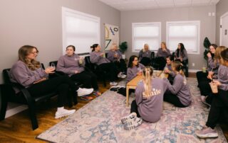 Dental team relaxing together in break room during morning meeting