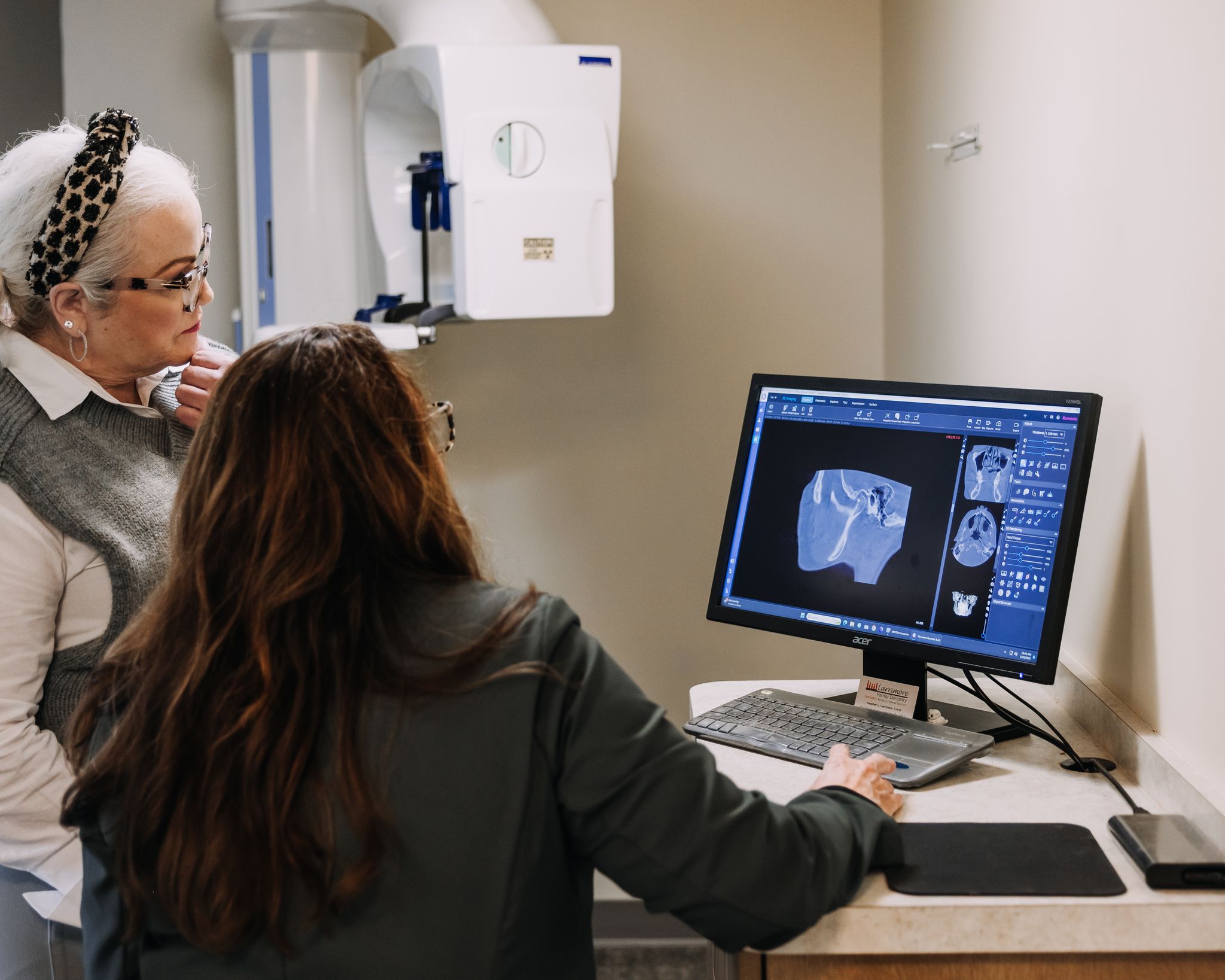 Holistic dentist reviewing advanced CBCT imaging with a patient during a wellness-focused consultation