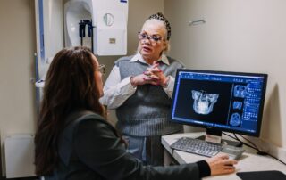 Dental coach discussing patient treatment planning and practice leadership using diagnostic imaging technology