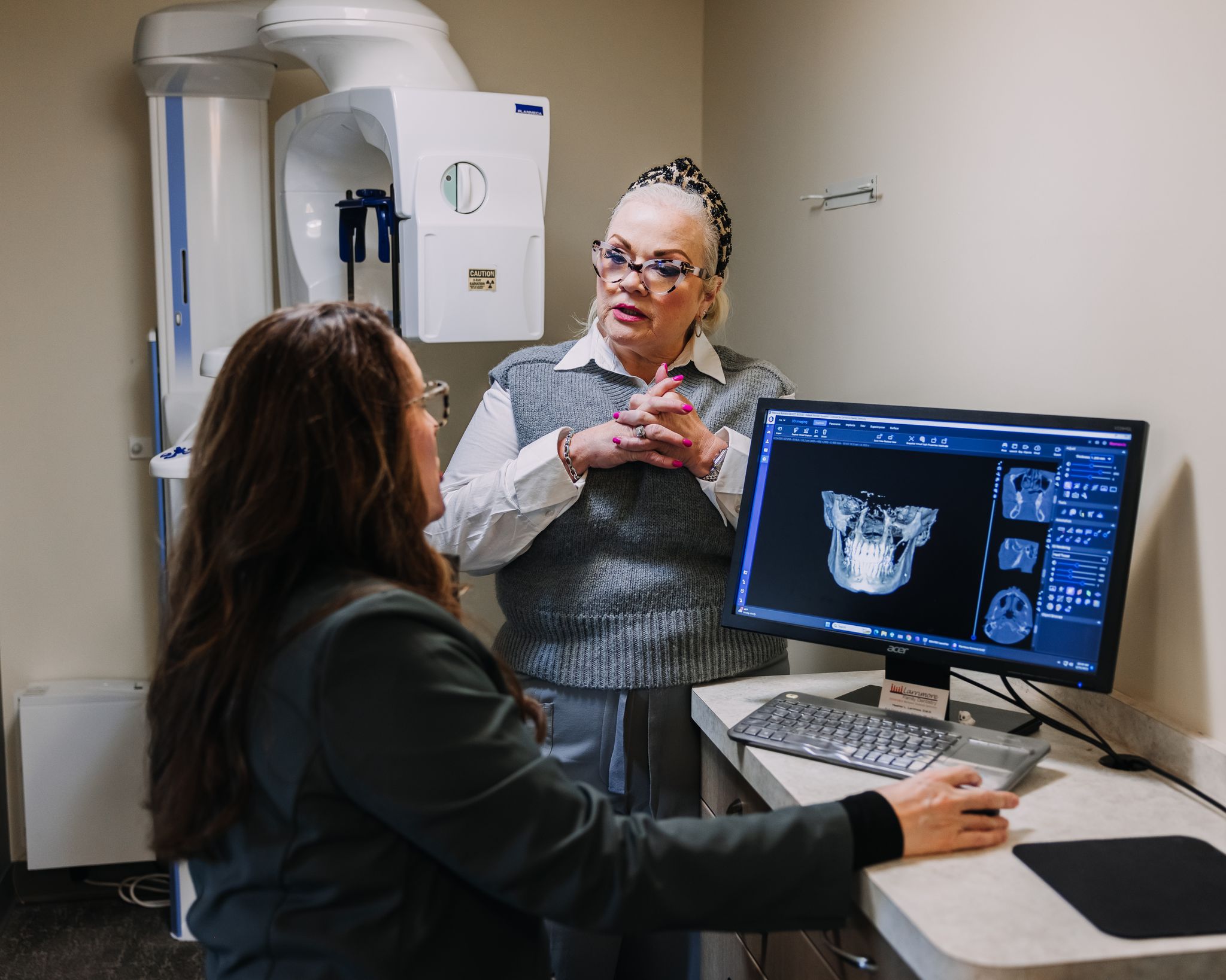 Dental coach discussing patient treatment planning and practice leadership using diagnostic imaging technology