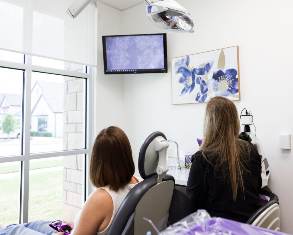 Dental patient and clinical team viewing microscope images together during visual patient education